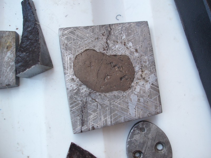 在美國亞利桑那州每年1月左右的礦物與化石市集所看到布滿韋德曼交紋的鎳鐵隕石標本，被包裹在中間的是隕硫鐵(Troilite)。