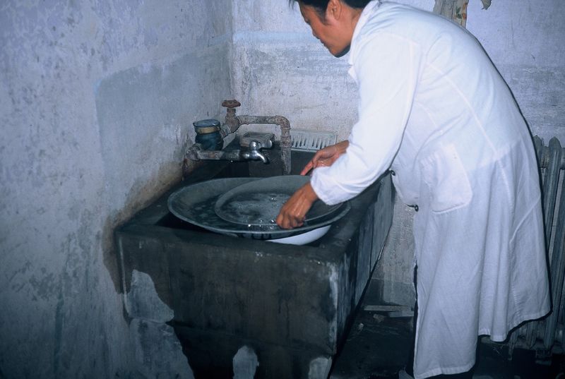 使用含少量肥皂的肥皂水，利用水流及手腕旋轉力道區分出輕、重礦物。（圖／董國安）