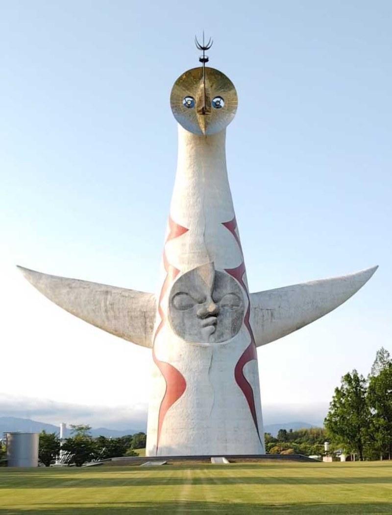 大阪萬博紀念公園裡矗立的「太陽之塔」以混凝土雕塑展現過去、現在與未來 3 種表情，紅色箭形紋飾則傳達源源不絕的生命能量。（圖／ 謝玉鈴）