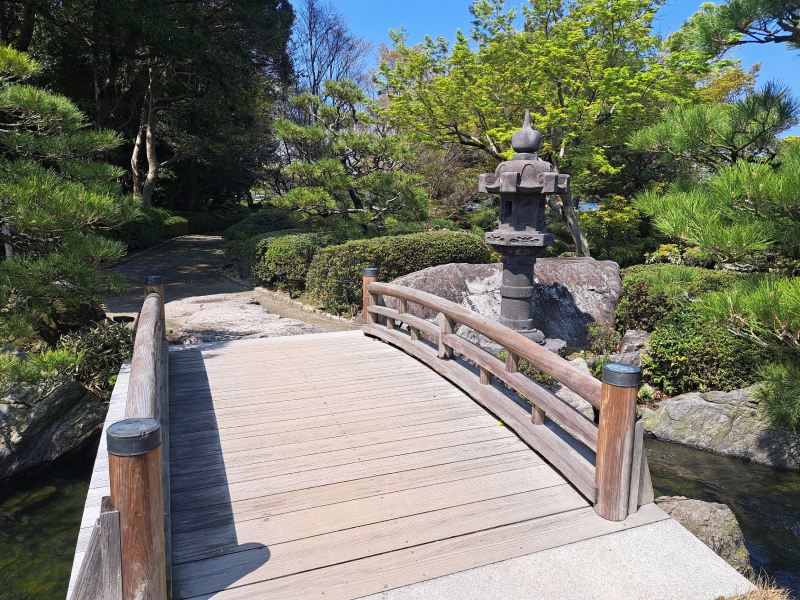 木橋、石燈籠與曲折園路,構成回迴遊式庭園的典型視覺節奏。(圖/王道華)